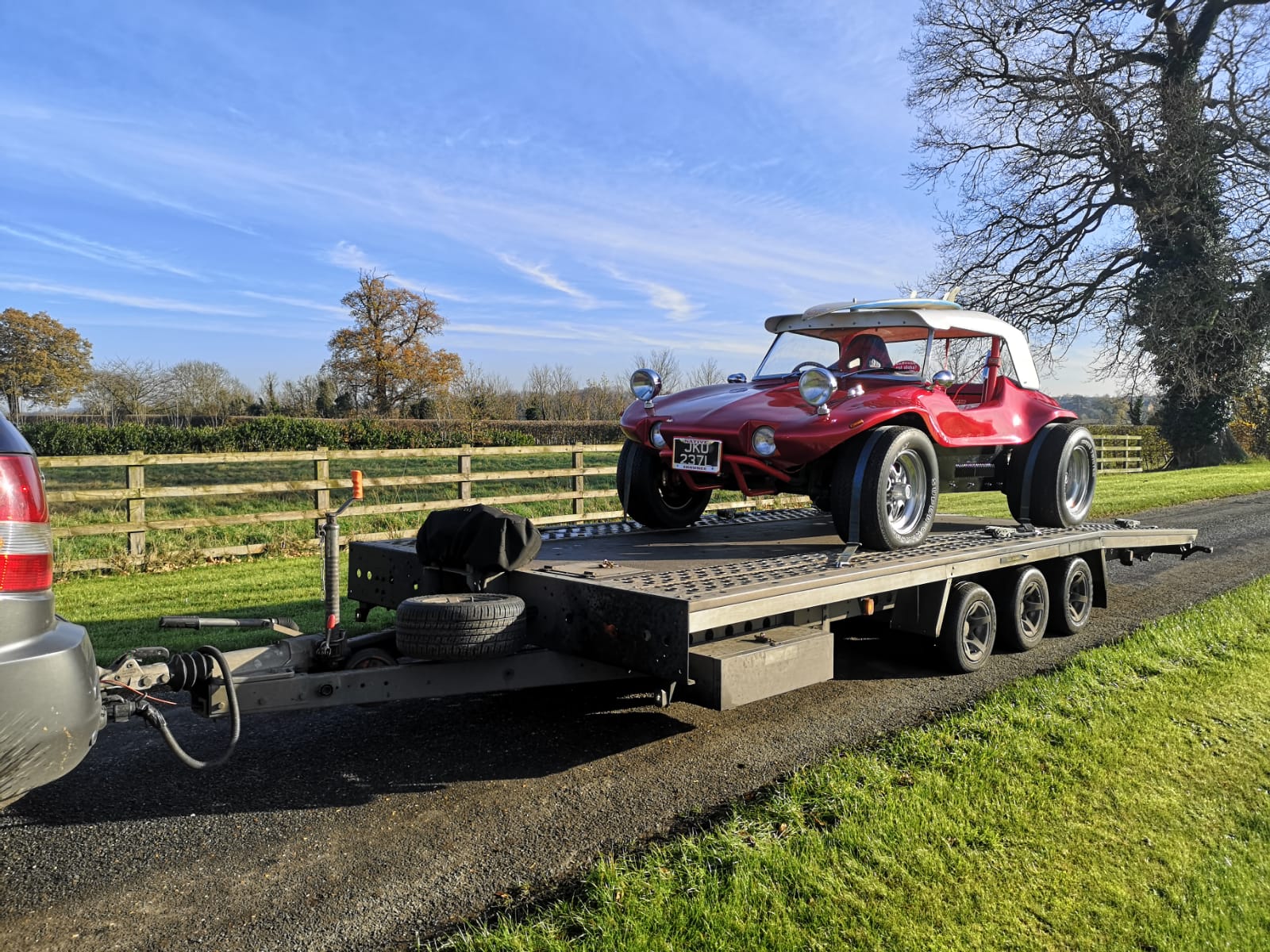 Red classic dune buggy on flatbed trailer