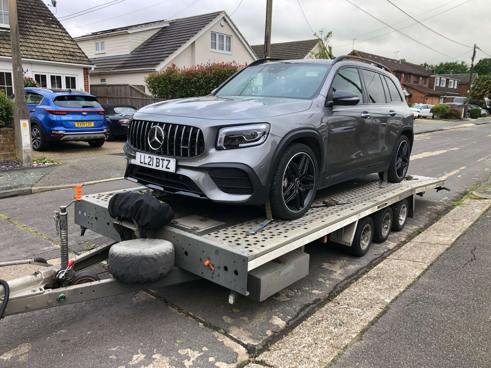 Mercedes-Benz AMG GLC on flatbed trailer in residential area