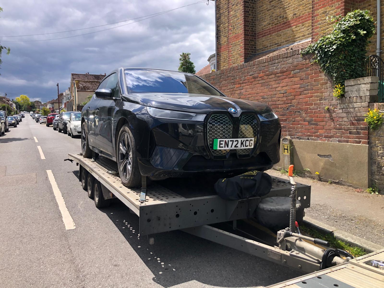 BMW iX electric SUV on flatbed trailer