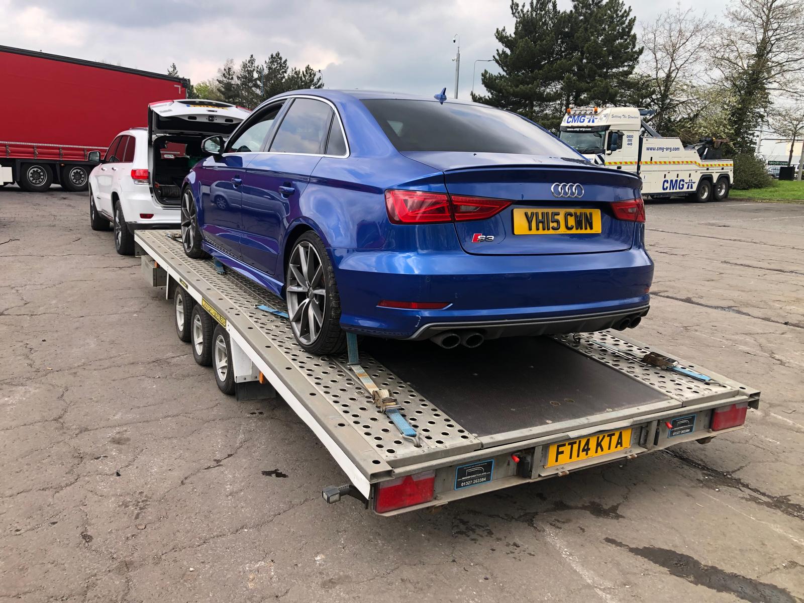 Blue Audi S3 performance sedan on flatbed trailer