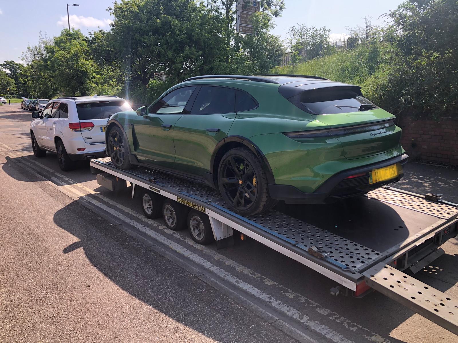 Green Porsche Taycan electric vehicle on trailer