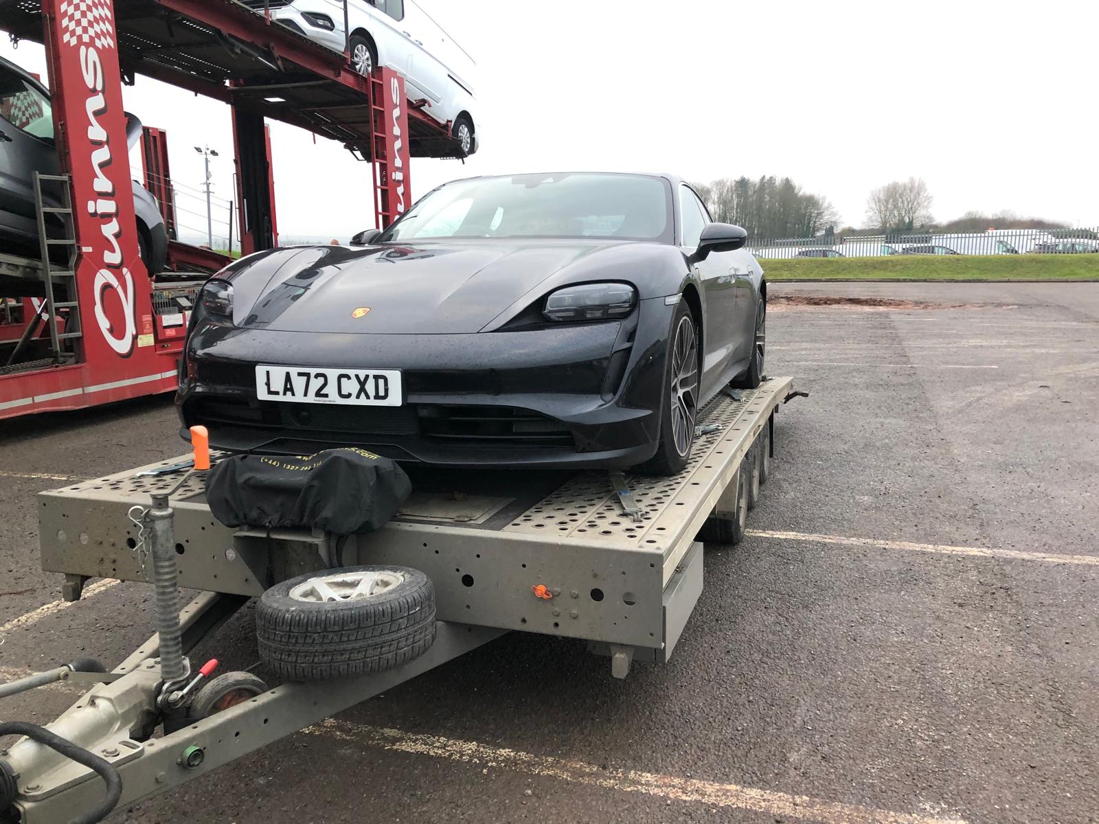 Black Porsche Taycan on flatbed trailer